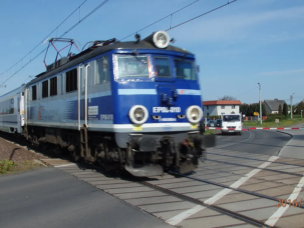 Pociąg na przejeździe — Kostrzyn Wielkopolski. Linia kolejowa biegnąca blisko trasy.